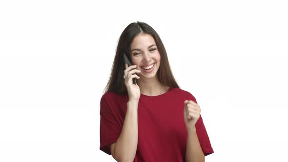 Attractive Cheerful Female Model in Red Tshirt Talking on Phone Smiling and Gesturing During