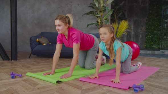 Mother Teaching Daughter Doing Bird Dog Exercise