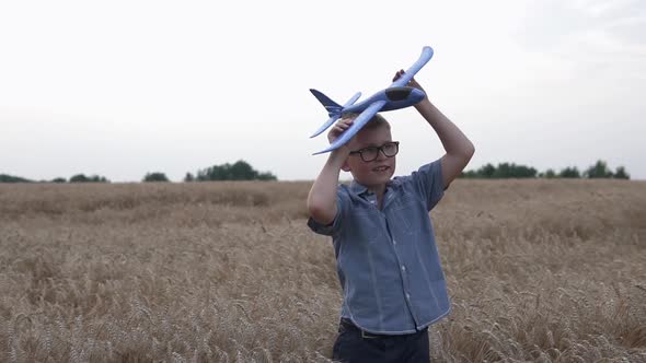 Happy guy with a toy airplane on a wheat field in the sunset light.