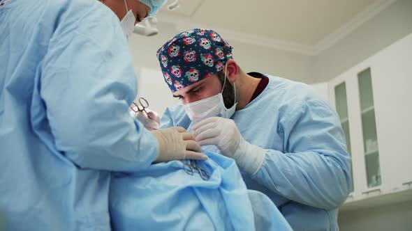 a male surgeon performs an operation