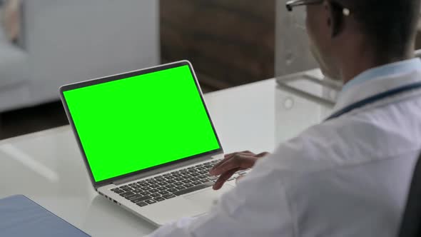 Young African Doctor Using Laptop with Green Screen