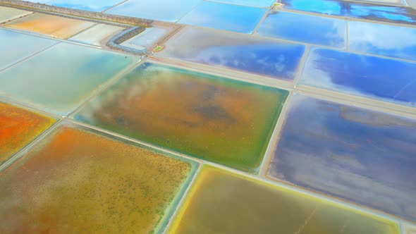 Aerial view flying over a beautiful colorful natural sea salt pond