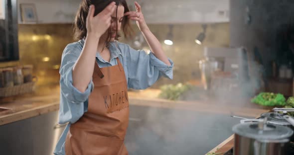 Housewife Hurries on the Kitchen with a Smoke From Burning Food