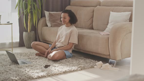 Biracial Girl Video Chatting with Friend on Laptop from Home