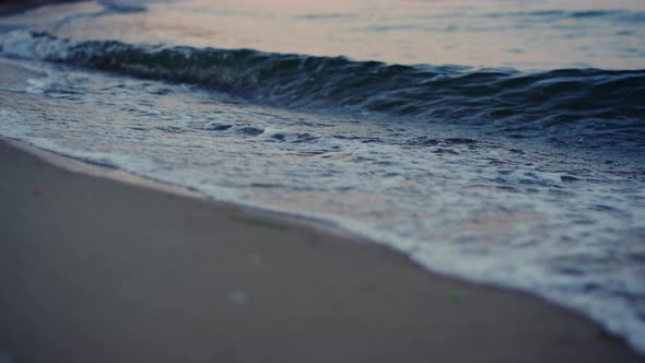 Close Up Blue Cold Ocean Waves Breaking Sandy Beach in Morning Dawn