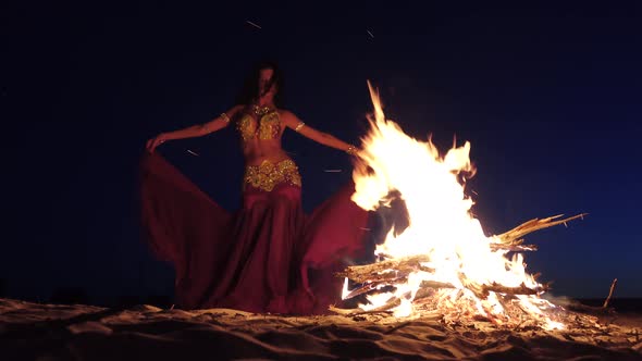 Night the Girl Dances Belly Dancing on the Sand, She Has a Bright Outfit