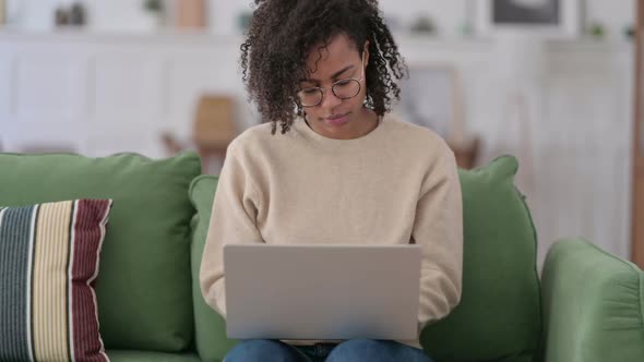 Beautiful African Woman Using Laptop on Sofa