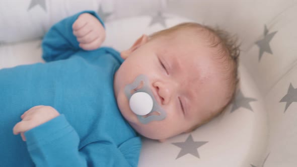 Little Child Sucks Dummy Falling Asleep on Rocking Crib