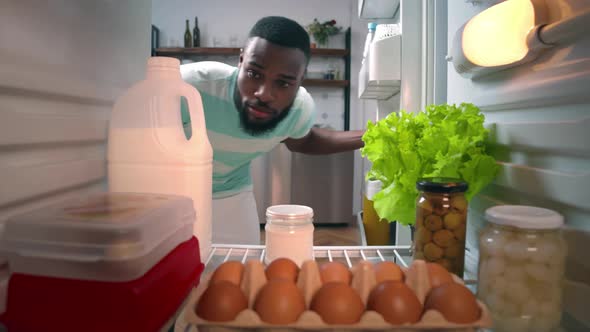 AfricanAmerican Ethnicity Man Opening Door of Fridge to Get Milk and Closing Door