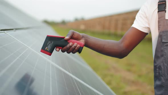 Technician in Helmet Using Thermal Imager on Solar Farm