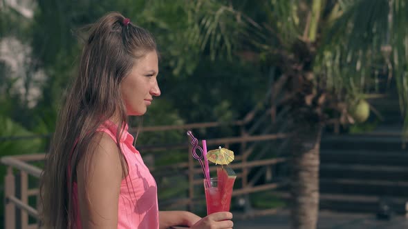 Slim Woman Holds Cocktail and Long Brown Hair Waves Slowly