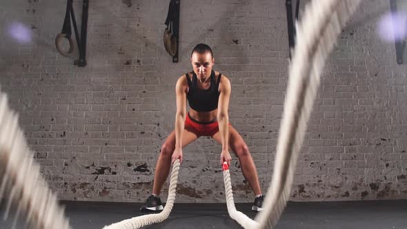 Athletic Young Woman Doing Some Crossfit Exercises with a Rope Indoor. Slow Motion