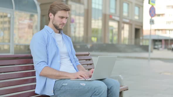 Rejecting Man in Denial While Using Laptop Sitting Outdoor on Bench