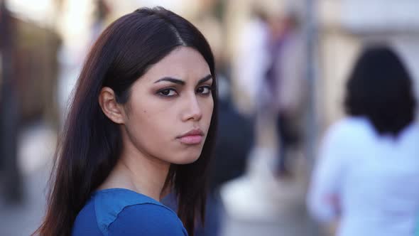 Sad and serious pretty oriental woman staring at camera- outdoor