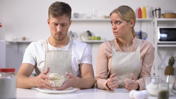 Clumsy Man Stretching Dough, Looking at Wife, Couple Has Difficulty Making Cake