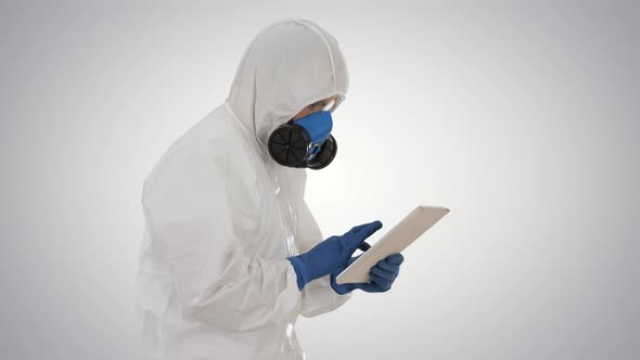 Scientist or Docrot Wearing Biohazard Suits and Protective Masks Using Digital Tablet While Walking