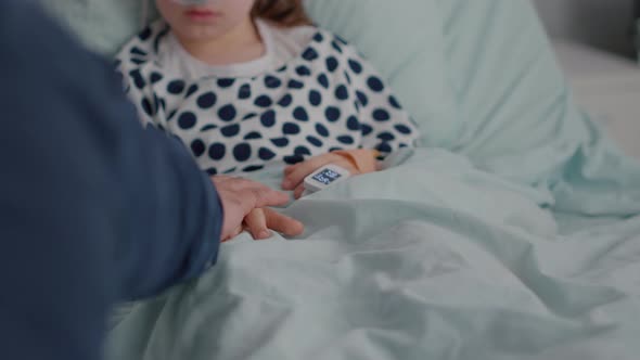 Closeup of Father Putting Hands on Sick Daughter After Suffering Recovery Surgery