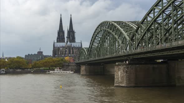 Timelapse of Cologne on Hohenzollern bridge and the Cathedral Dom on the background with boats passi