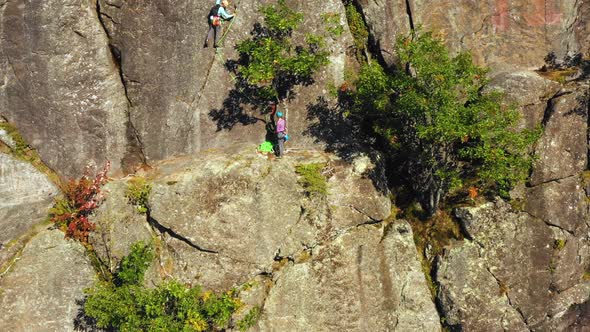 Aerial footage Lift up past a pair of climbers on a cliff in Maine.mp4