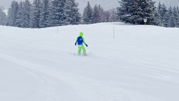 Boy on Snowboard Ride Downhill During Strong Snowfall