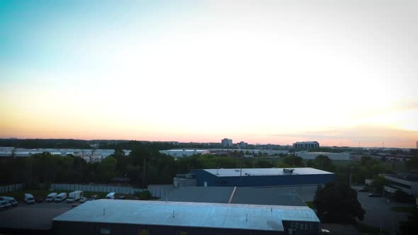 Drone flying over an industrial park during sunrise.