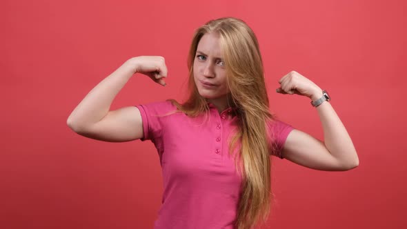 Young Woman Points To the Strong Hands on a Red Background