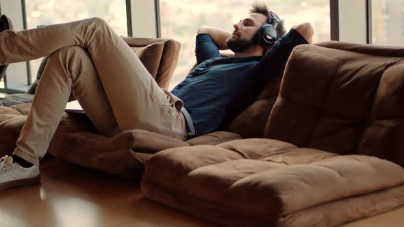 Man Sitting On Workplace And Listening Podcast. Businessman Leisure In Headphone.