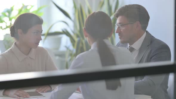 Serious Businessman Talking Businesswoman in Modern Office