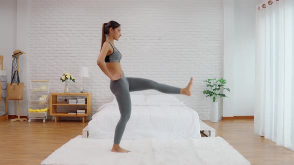 Athletic Healthy Asian woman in sportswear workout excercise at home