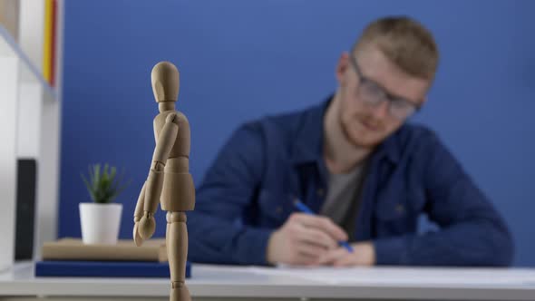 Young Architect in Glasses Designs a Wooden Gestalt Figure. The Creative Process