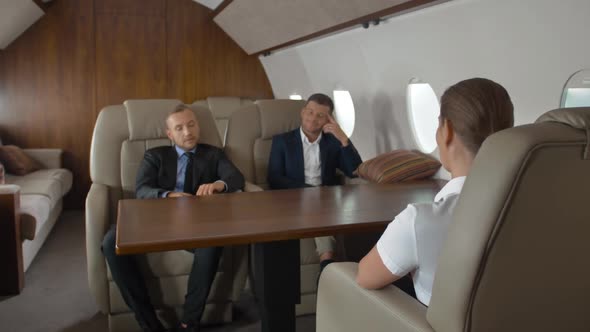 Two Confident Male Entrepreneurs and Successful Female Businesswoman Inside Air Plane