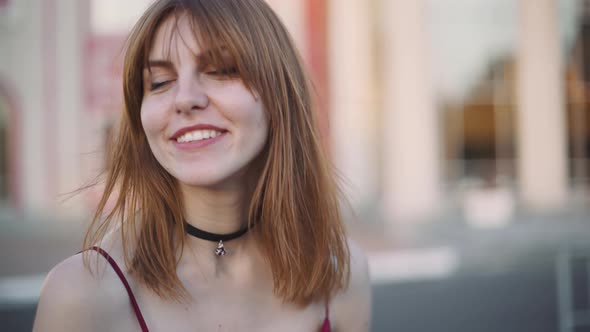 Beautiful Young Redhaired Woman Motorcyclist with Her Motorcycle and Helmet