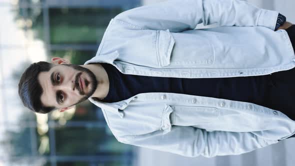 Vertical Screen of Bearded Man Standing Look at Camera Serious Outside Near Business Center