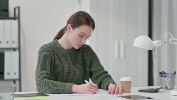 Young Woman Writing on Paper