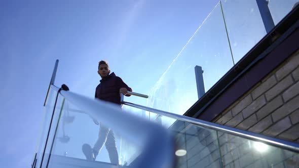 Confident Young African American Man Walking Downstairs From Rooftop Terrace on Sunny Day