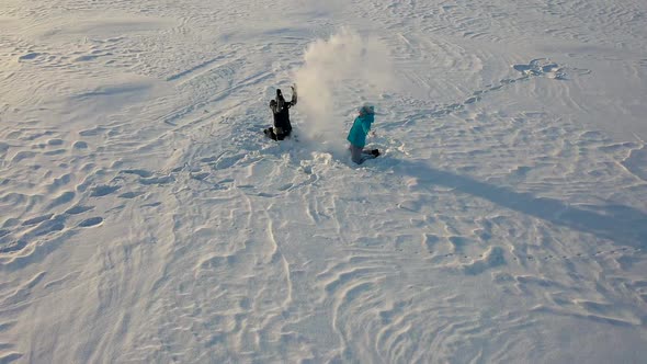 Girl and Boy Throw Snow on Each Other and Enjoy It in the Winter Park