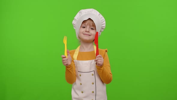 Child Girl Dressed Chef Cook with Fork and Knife Waving Head Approval on Chroma Key Background