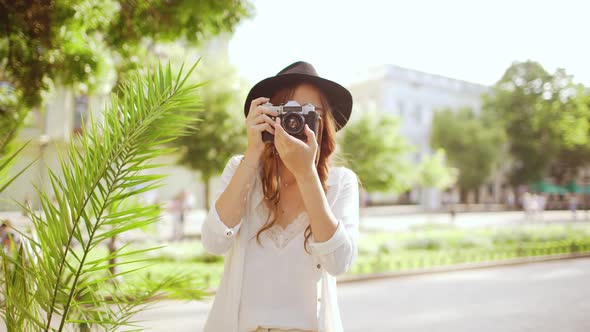 Young Beautiful Girl Photographing in City Park