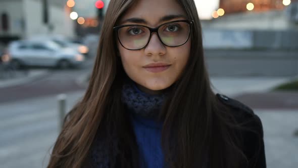 Portrait of young beautiful eastern woman in city sunset looking in camera smiling