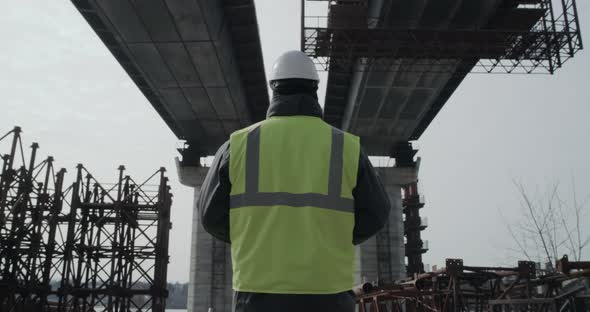 Unrecognizable Engineer Examining Concrete Bridge