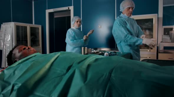 Two Experienced Surgeons in Special Robes Come to the Operating Room