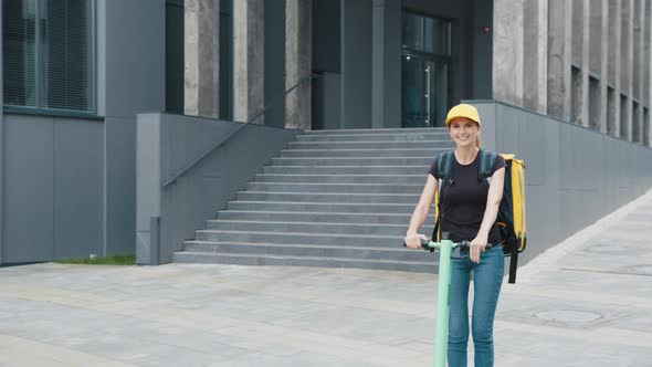 Delivery Service Woman Riding Scooter in Big Modern City