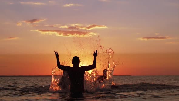 Silhouettes of Father with Two Sons 1012 Swimming in Sea and Splashing Water Together During