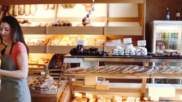 Female baker holding croissants in basket