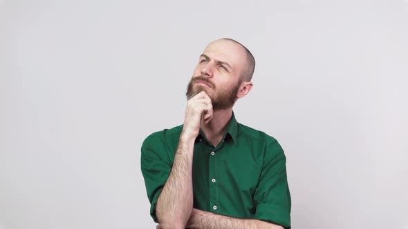 Portrait of serious bearded man thinking or remembering, isolated over white background.