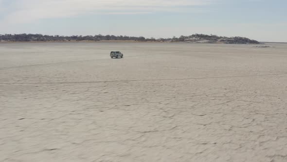 4x4 Car Driving On Dry Salt Pan Of Makgadikgadi Towards Kubu Island (Ga'nnyo) In Botswana, South Afr