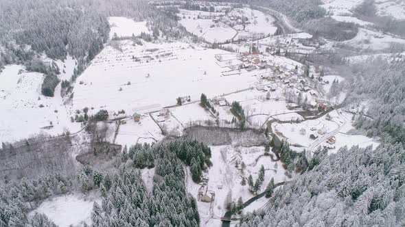 Village between the forest covered in snow during winter time