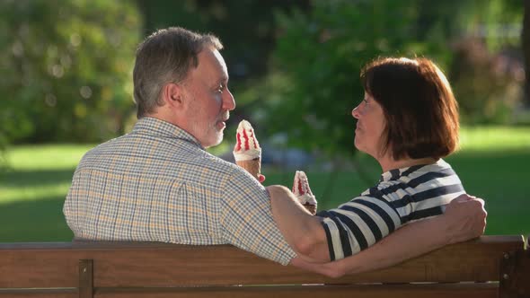 Senior Couple Eating an Ice-cream on Bench at Park.