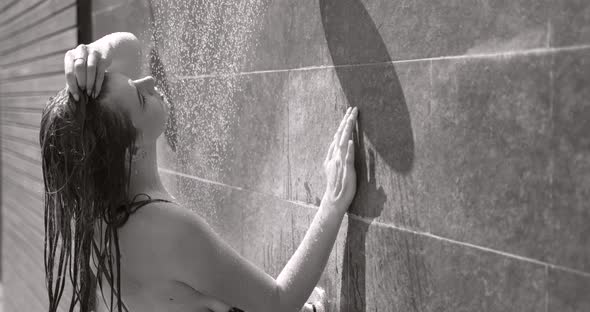 A Girl is Taking Shower After Sunbathing Outdoors