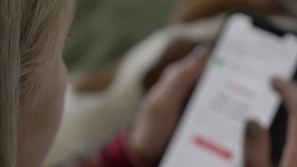 woman lying on the sofa using her phone, surfing the internet